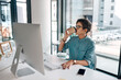 © peopleimages.com - Creative, drinking coffee and business woman on computer for project research, report or graphic designer reading startup email. Desktop, tea and professional on internet for networking in office