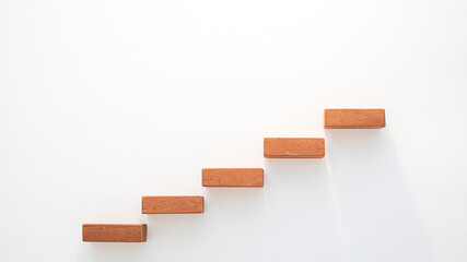 An upward staircase made of bricks symbolizes steady business growth against a white background