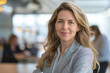 © Daniil - Beautiful business girl in a suit smiles. Against the background of the office