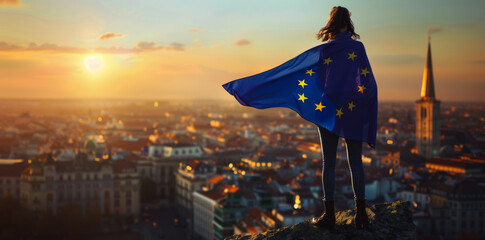 Wall Mural - A woman wearing the flag of the European Union e is standing on top overlooking a city during the golden hour