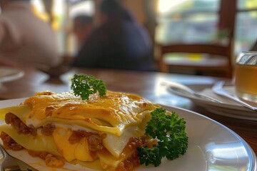 Wall Mural - Close-up of a delicious lasagna served on a white plate with parsley garnish, set on a rustic wooden table in a cozy restaurant.