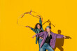© VISTA by Westend61 - Smiling woman waving multi colored ribbon with lesbian friend in front of yellow wall