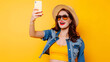 © john - Portrait of cool cheerful girl having video-call with lover holding smart phone in hand shooting selfie on front camera isolated on yellow background enjoying weekend vacation