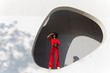 © VISTA by Westend61 - Woman in red jumpsuit standing with binoculars shielding eyes on sunny day