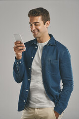 Poster - Studio, man and smartphone for chatting, networking and funny news with contact on social media. Creative worker, scroll and browse on dating app with humor, text and connection by gray background