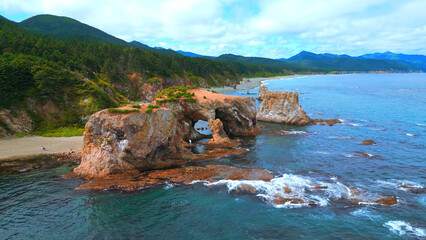 Wall Mural - Top view of beautiful coast with rocky arches. Clip. Amazing nature of erosion in sea rocks on coast. Wild beach with coastal cliffs and stone arches