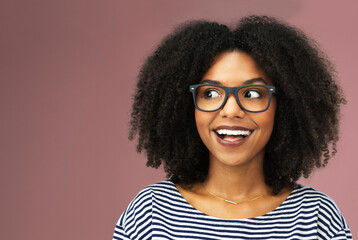 Wall Mural - Glasses, thinking and excited black woman with idea, vision or planning isolated on pink studio background space. Eyewear, inspiration and dream of future decision, laugh or brainstorming to remember