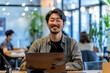 © AI_images - a Japanese professional exuding confidence and positivity at a contemporary startup workplace.
