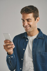 Poster - Studio, man and cellphone for chatting, networking and funny news with contact on social media. Creative worker, scroll and browse on dating app with humor, text and connection by gray background