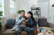© itchaznong - Elderly married couple who are retired are relaxing together in living room, using mobile