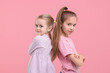 © New Africa - Portrait of cute little sisters on pink background