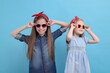 © New Africa - Cute little sisters on light blue background