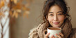 © alenagurenchuk - Middle-aged Asian woman holding a cup of coffee