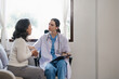 © Natee Meepian - Doctor consulting with senior woman on sofa in home. Healthcare and patient support concept