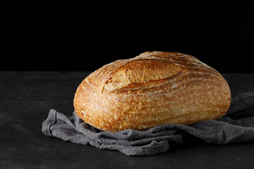 Fototapete - Traditional rustic sourdough bread on a towel. Baked artisan bread on table