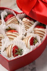 Poster - Heart shaped box with delicious chocolate covered strawberries on white marble table, closeup