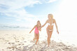 © Grady Reese/peopleimages.com - Happy, woman and kid at beach with running for summer adventure, bonding and vacation in sunshine. Sea, nature and mom with girl on sand by ocean for holiday, travel and weekend trip in California