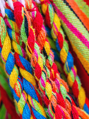 Wall Mural - Colorful cotton rope. Thick cotton rope showing detail of threads and fibres. Yarn braid rope of cradle. Multicolored yarn has been braided into a braid. Knitted fabric background. Selective focus.