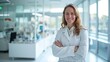 © AlfaSmart - Confident female doctor in a lab coat standing in a bright, modern medical office