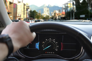 Canvas Print - Man driving modern car on city street, closeup