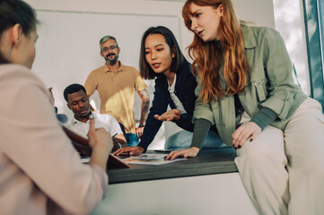 Wall Mural - Asian businesswoman having a meeting with her diverse colleagues at work