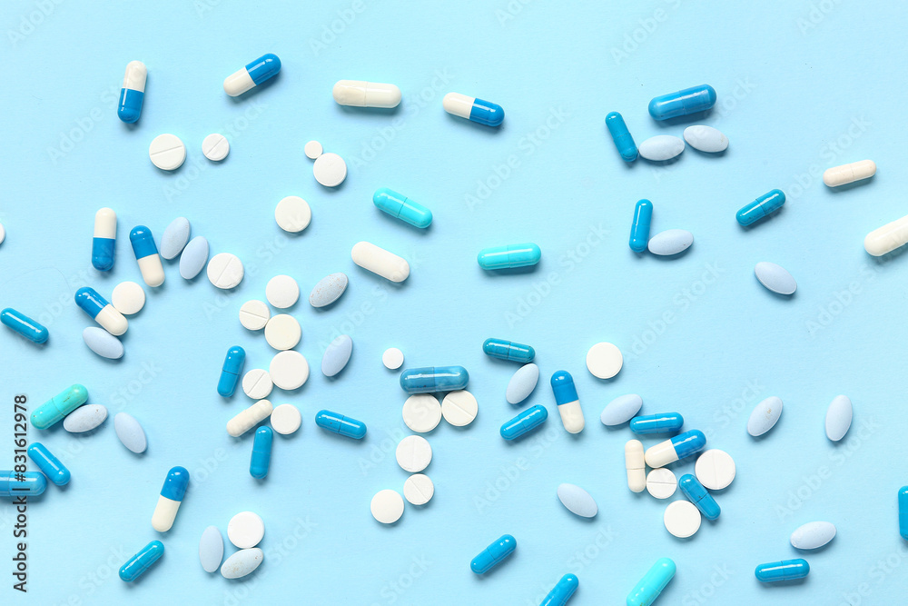 Many different pills on blue background