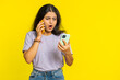 © Andrii Iemelianenko - Irritated nervous stressed Indian woman talking screaming on two mobile phones having conversation conflict quarrel complaint dispute discuss solve problem. Arabian girl isolated on yellow background