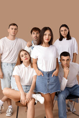 Wall Mural - Group of stylish young people on brown background