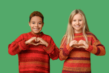 Poster - Cute little children showing heart gesture on green background. Valentine's day celebration