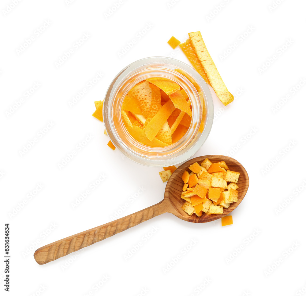 Glass jar and spoon with fresh orange peel on white background