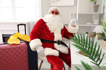 Poster - Santa Claus with headphones showing victory gesture at home. Christmas in July