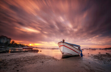 Wall Mural - boats waiting in the reflective water clouds in the sky sunset colors