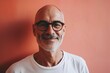 © Stocknterias - Portrait of a smiling senior man with glasses on a pink background