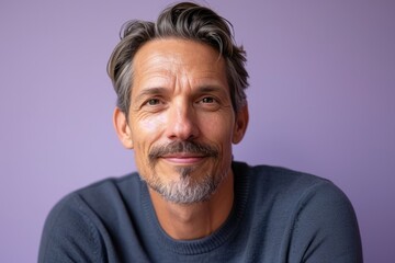 Wall Mural - Portrait of handsome mature man with grey hair and beard looking at camera