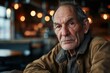 © Stocknterias - Portrait of an old man sitting in a pub, looking at the camera.