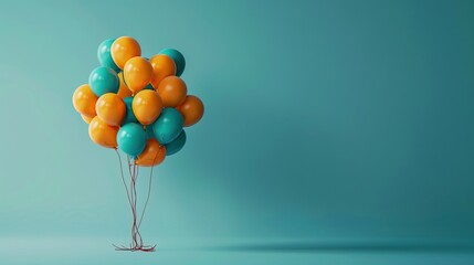 Cluster of orange and teal balloons on a turquoise background, concept of celebration and party