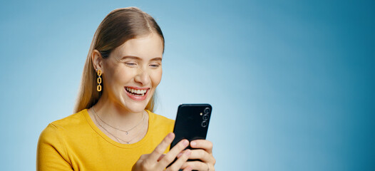 Poster - Funny, woman and phone text in studio with social media, smile and meme with mockup for banner. Digital, email and technology with typing, blog and mobile app with notification and blue background