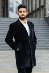 Portrait of happy Indian businessman smiling friendly, glad expression looking at camera, feel satisfied good news outdoors. Arabian Hindu freelancer in downtown city street. Business people lifestyle