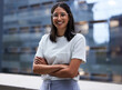 © N Lawrenson/peopleimages.com - Woman, smile and outside on balcony with arms crossed for happiness in portrait with pride for company. Glasses, designer and employee with outdoor office for relax on break in urban town in New York