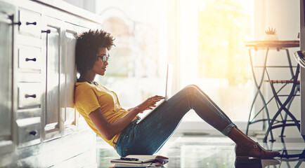 Poster - Black woman, kitchen and relax on floor with laptop for blog update, digital content creation and remote work for freelance job. Girl, home and technology for blogging, writing and email notification