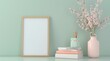 © Sabina Gahramanova - mockup of blank wooden frame with copy space on the table in modern interior design, vase flowers and books on soft pastel green wall background. Concept of interior decoration and furniture design.