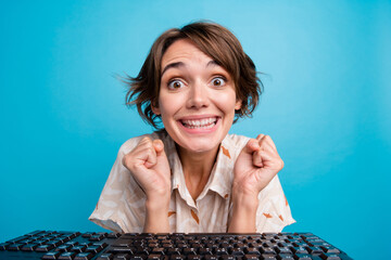 Sticker - Photo of cheerful glad girl professional hacker celebrate success raise fists yes isolated on blue color background