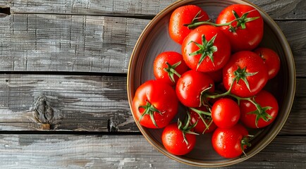 Wall Mural - Plate of red tomatoes on a wooden table, top view.