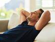 © Lyndon Stratford/peopleimages.com - Home, relax and man on sofa, smile and resting with weekend break, afternoon nap and carefree in living room. Apartment, person and guy on couch, dreaming and wellness with meditation and sleeping