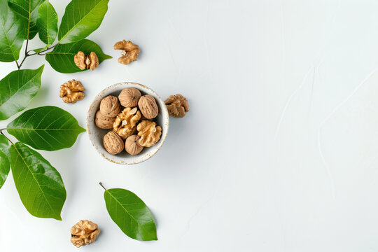 a bowl of nuts and leaves on a white surface