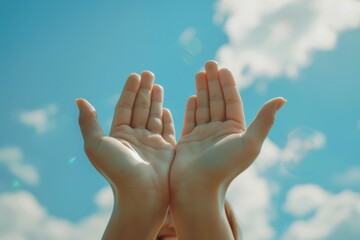 Wall Mural - Two hands are held up against a bright blue sky with fluffy clouds, each palm adorned with a simple smiling face drawn on them.