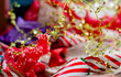 © Connect Images - A vibrant and festive close-up of Christmas wrapping paper and decorations featuring red and white stripes, snowflake patterns, and golden star garlands.
