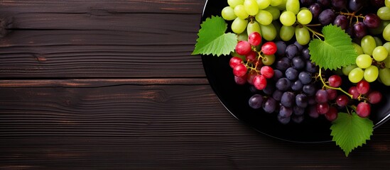 Aufkleber - top view of various types of grapes on vintage plate on black wooden surface. Creative banner. Copyspace image