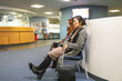 © Connect Images - Two people sitting in a waiting area of a medical practice