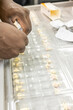© Connect Images - Hands packaging medication into pill organizers